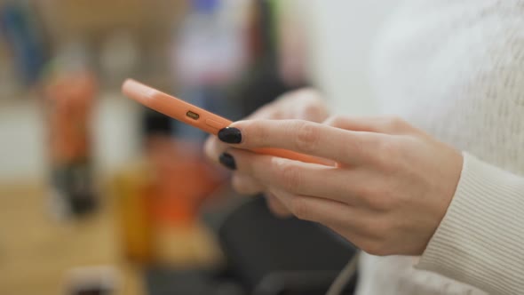 Woman Hands with Black Nails Typing Fast on Phone Screen alt