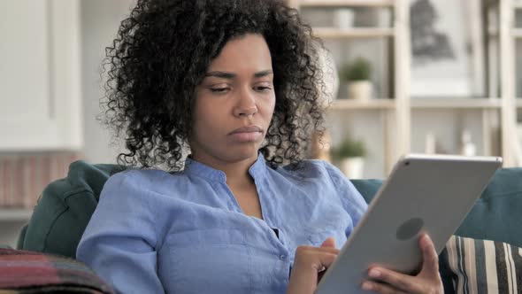 Relaxing African Woman Using Tablet alt