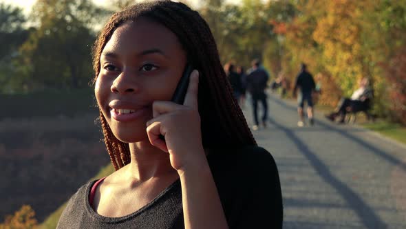 Young Beautiful Black Woman Phone in the Park in Autumn Day - Closeup alt