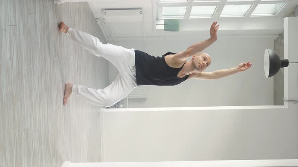 Fit Man Performs Elements of Modern Dance From a White Studio