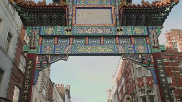 Upwards looking, smooth walking shot of the big entrance gate in Chinatown London. alt