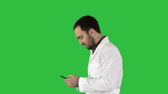 Man doctor walking and looking attentively at screen of alt