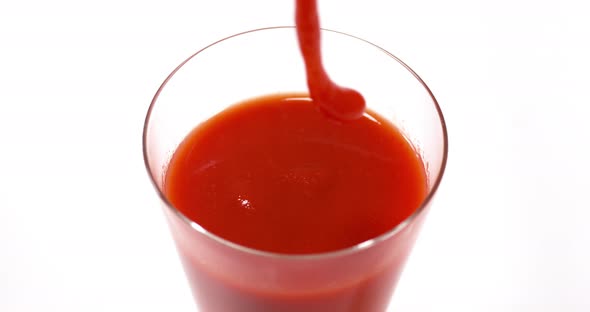 Tomatoe's Juice being poured into a Glass against White Background, Slow Motion 4K alt