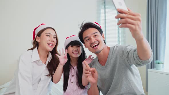 Asian Parents with little kid daughter video call online with family during holiday Christmas time. alt