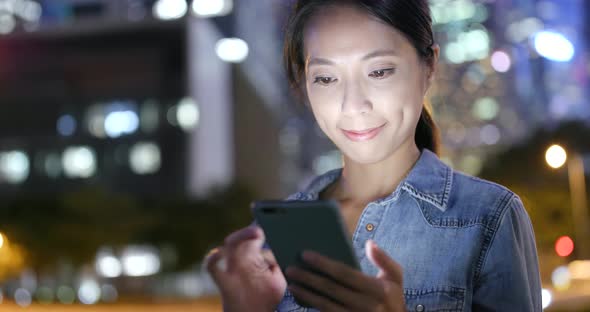 Woman use of mobile phone in Hong Kong city at night  alt