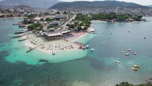 Aerial Azure Beach with Empty Sun Loungers and Boats Balkan Sea Coast Albania alt