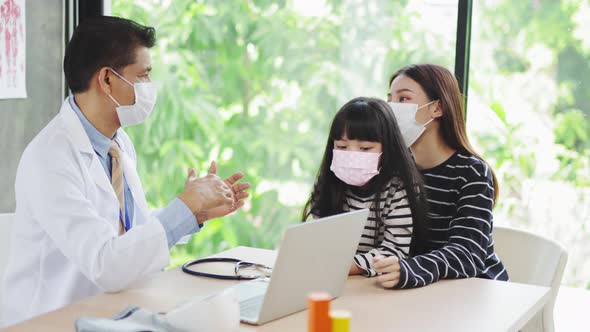 Asian  senior doctor wearing gloves and isolation mask is making a COVID-19 vaccination alt