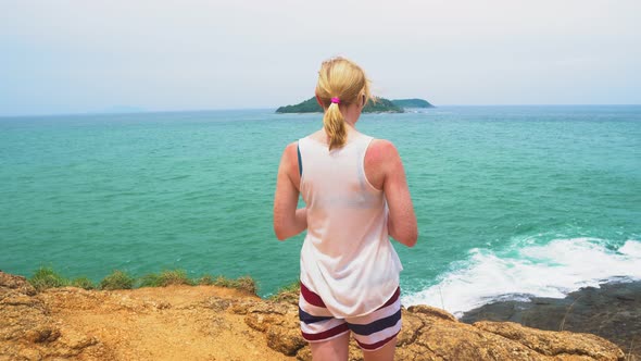 Woman Is Looking at The Sea. Beautiful Seascape with An Island. Waves Beat Against the Rocks alt