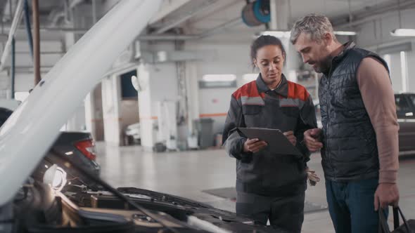 Sequence of Female Auto Mechanic Finishing Repairs alt