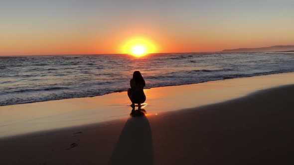 Silhouette of Young Woman on Beach During Sunset