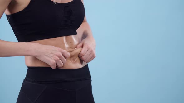 Sports Woman Touches with Hands a Muscular Belly in the Studio Closeup alt