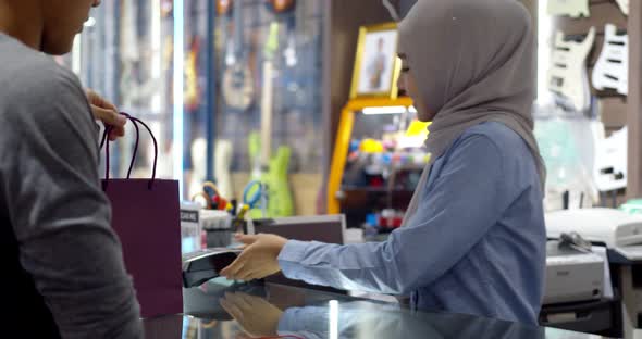 Young muslim man use smartwatch paying over contactless transactiona at cashier counter  alt
