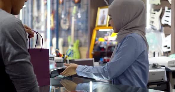 Young muslim man use smartwatch paying over contactless transactiona at cashier counter 