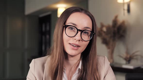 Businesswoman in Eyeglasses Talking to Business Partner By Web Cam of Laptop alt