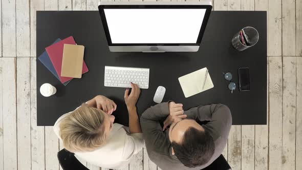 Business Couple Talking and Watching Image on Screen of Monitor. White Display alt