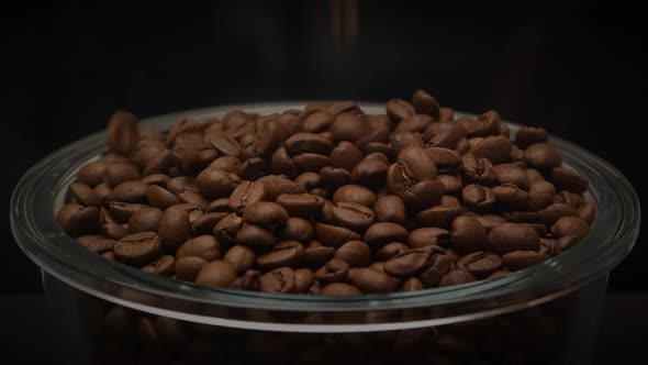 Aromatic Roasted Coffee Beans Falling Into Glass Plate on Dark Background in Slow Motion alt