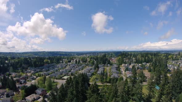 Drone Reveal Of Neighborhood Houses In Rural Hills With Thick Trees alt