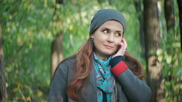 Attractive Hair Talking on the Phone While Standing in the Autumn Forest alt