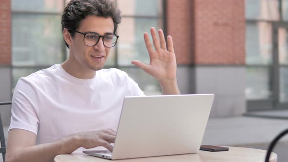 Online Video Chat on Laptop by Young Man Sitting Outdoor alt