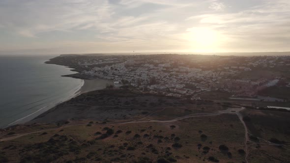 Aerial wide push out over Praia da Luz landscape, Algarve at Sunset alt