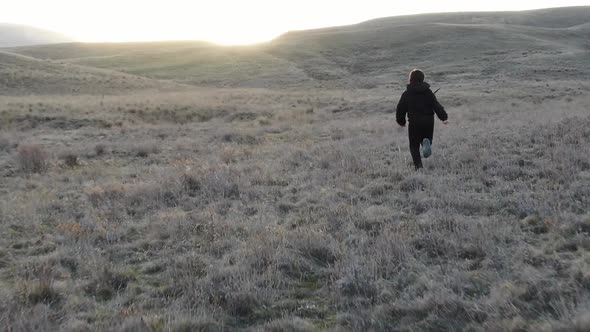 Slow Motion Boy Running Down the Hill on the Sunset Background