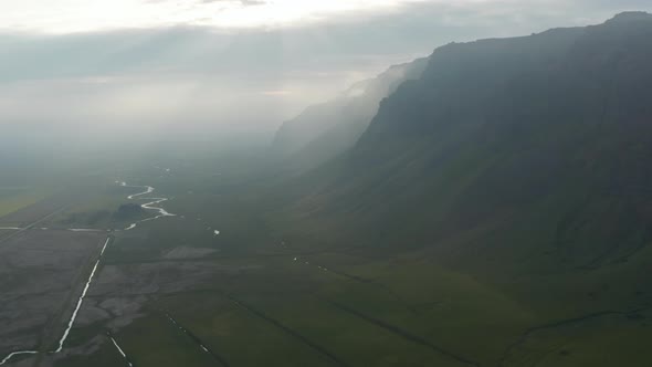 Aerial Panoramic View of Hazy Landscape Against Sun Shining Through Clouds alt