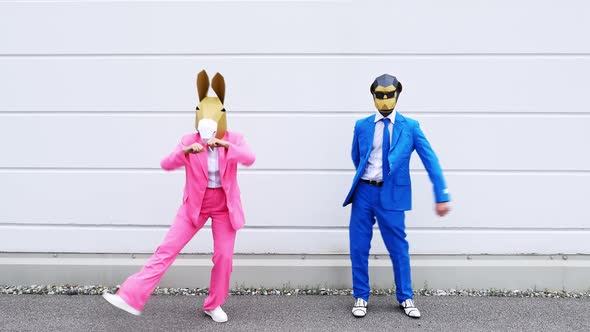 Business people wearing animal masks dancing in front of white wall