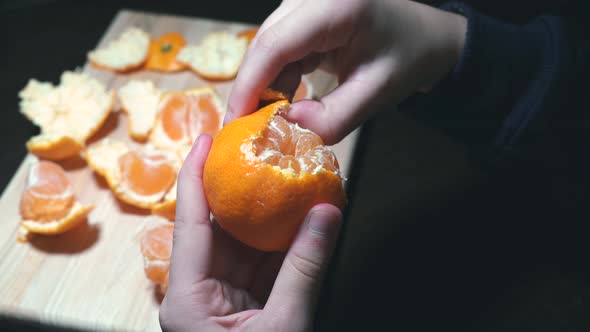 hands close-up clean from the rind of the Mandarin