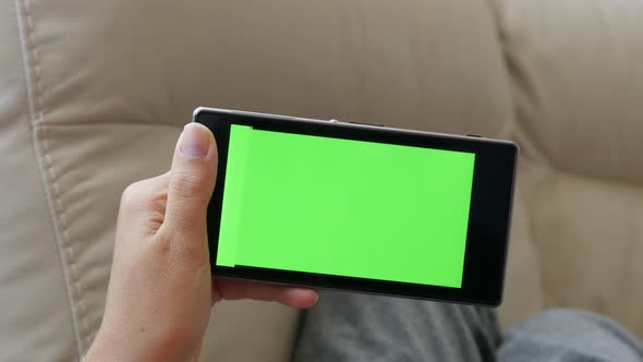 Woman scrolling through smart phone green screen display pages  4K 2160p 30fps UltraHD footage - Gre