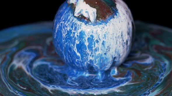 Paint Flows Down the Surface of the Texture Ball and Spreads Over the Table alt