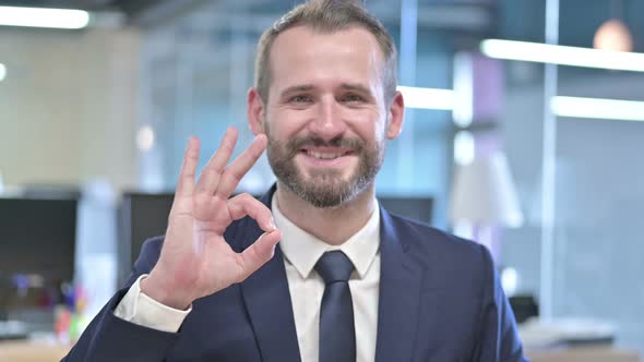 Portrait of Cheerful Businessman Showing Ok Sign in Office alt