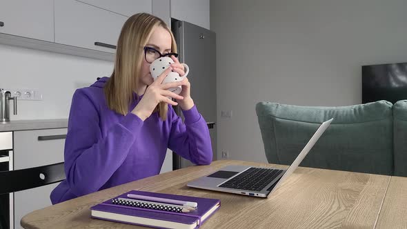 Pensive Young Adult Woman in Glasses Work Study at Kitchen Using Laptop alt
