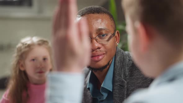 AfricanAmerican Teacher Nods Listening to Student Answer alt