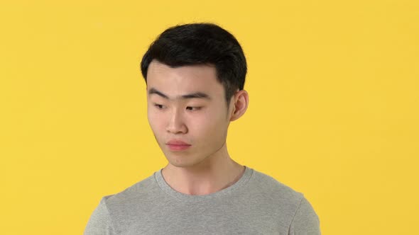 Sad young asian man crying in front of camera