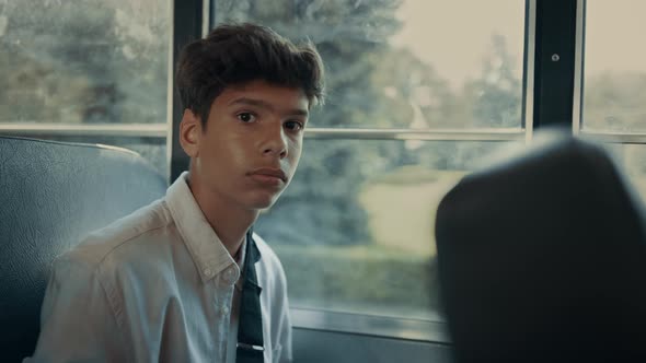 Pensive Indian Boy Sitting at School Bus Window Closeup alt