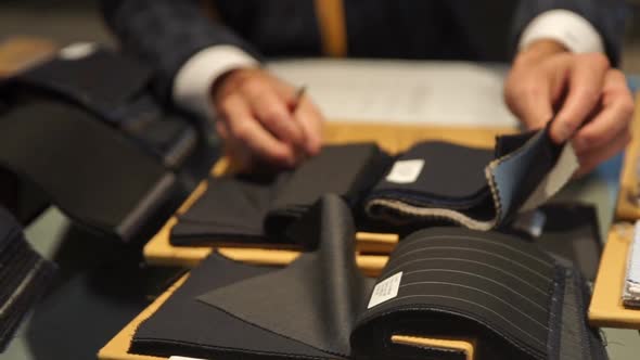 Crop tailor looking through cloth samples alt