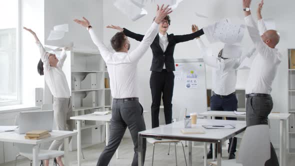 Ecstatic Colleagues Throwing Documents in Air alt
