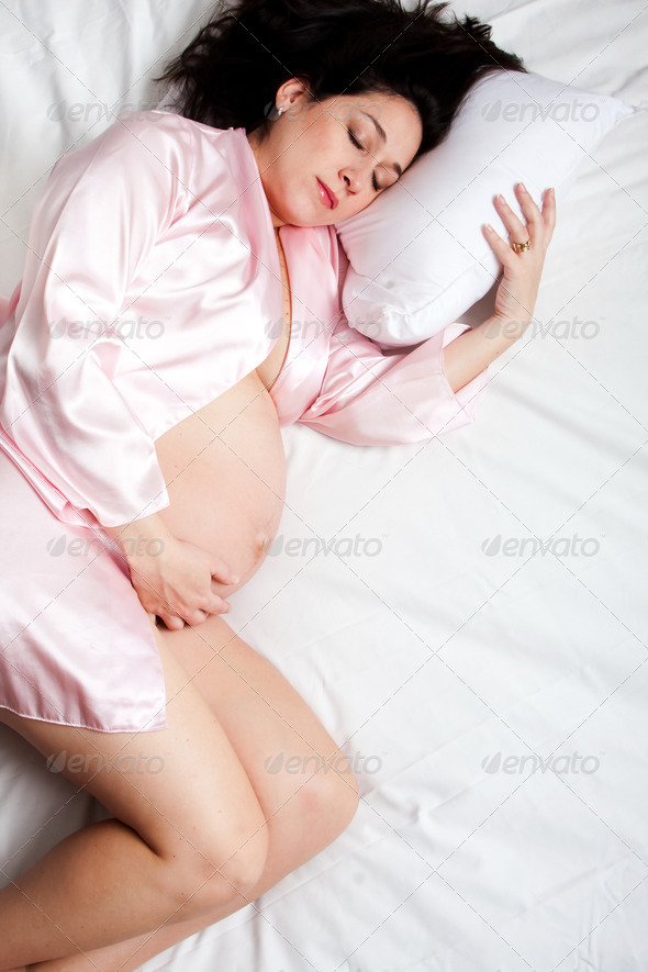 Sleeping pregnant woman in bed - Stock Photo - Images