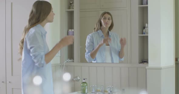 Woman looking into mirror in domestic room