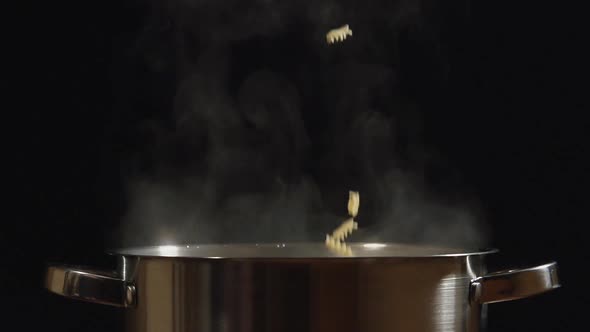 Pasta Fall To A Steel Pan On A Black Background