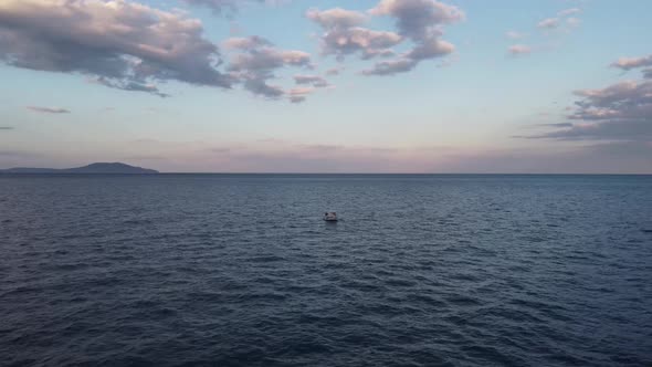Lonely Boat in the Open Sea Against the Backdrop of Bluepink Evening Sky