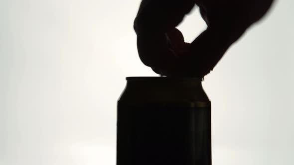 The Silhouette of Male hands opening a aluminum can