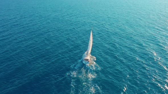 Aerial View. Yacht Sailing on Open Sea at Sunny Day. Sailing Boat in Sea alt