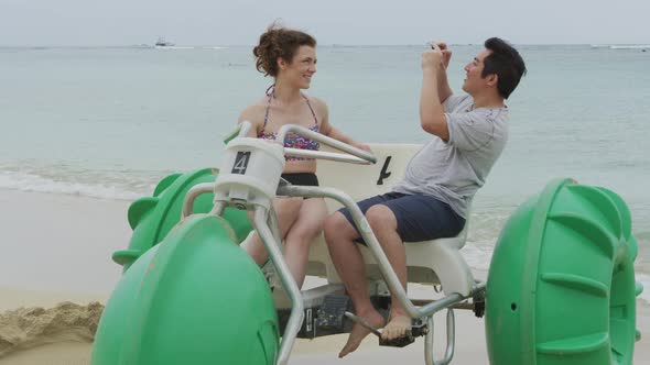 Couple taking cell phone photos on water tricycle in Hawaii