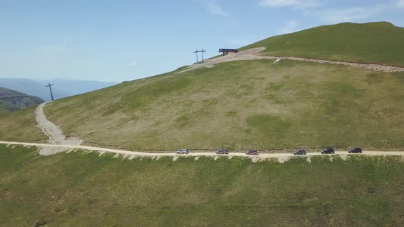 Aerial view of a group of cars rides along the mountains Kolasin in spring in Montenegro. alt