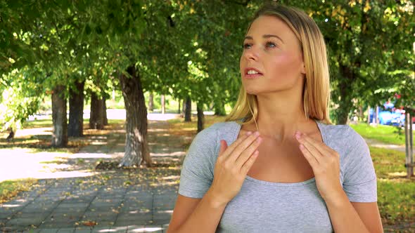 Young Pretty Blond Woman Is Suprised - Park with Trees in Background alt