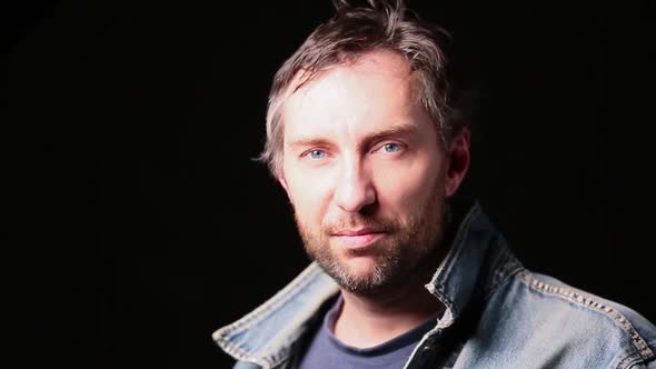 Close Up Portrait of a Blue Eyed Bearded Middle Aged Biker Taking on Helmet. alt