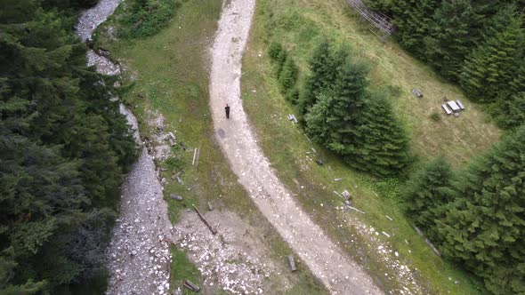 Aerial Drone Shot of an Active Young Man Walking in a Fairy Stream in Romania