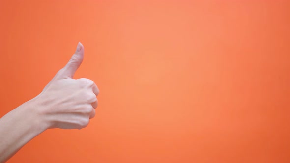 Woman Gives a Thumbs Up on an Isolated Orange Background