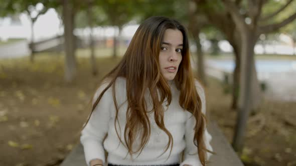 Young Woman in Park is Offended and Moves Backward Portrait Shot alt